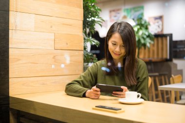 Kafede cep telefonu kullanan kadın