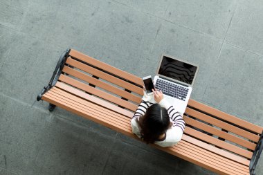 dizüstü bilgisayar ve cep telefonu kullanan kadın