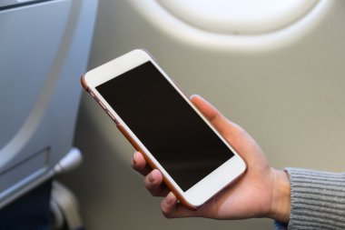 uçak içinde cep telefonu kullanan kadın