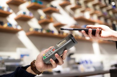 Fatura ödeme için cep telefonu kullanan kadın