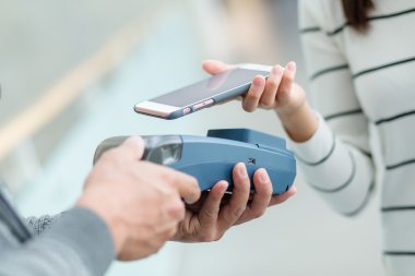 Fatura ödeme için cep telefonu kullanan kadın