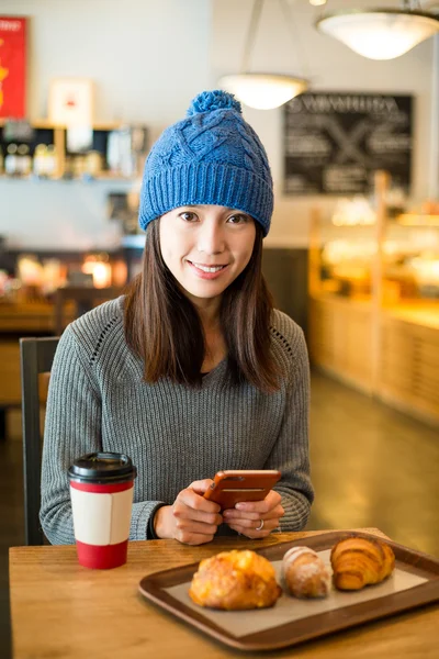 Woman using mobile phone in coffee shop — Stock Photo, Image