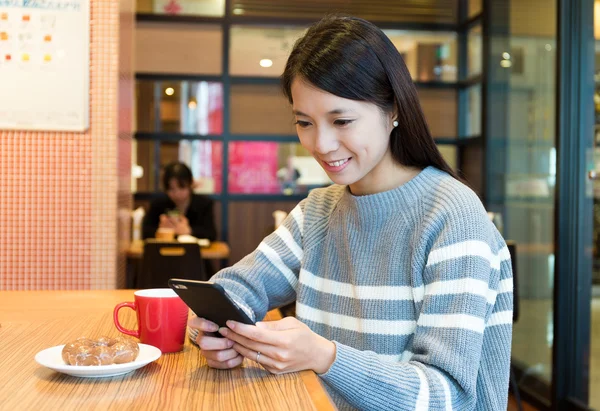 Женщина, использующая мобильный телефон в кафе — стоковое фото