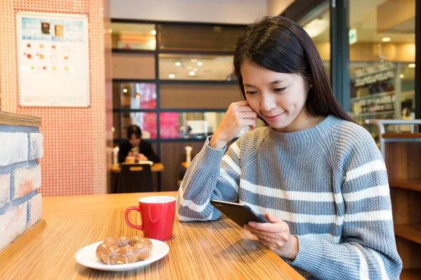 kahve dükkanında cep telefonu kullanan kadın