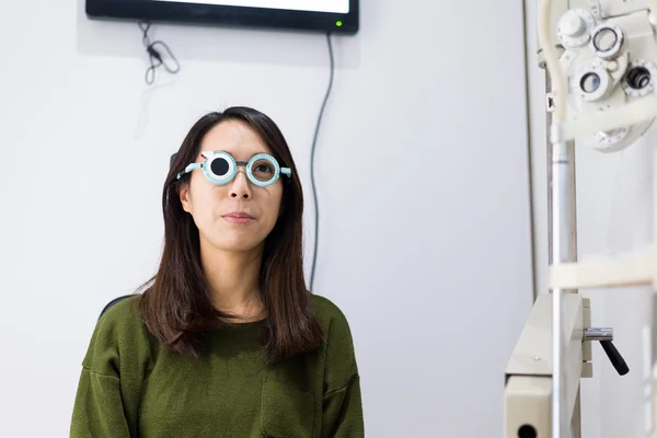 Женщина делает тест на зрение в оптической клинике — стоковое фото