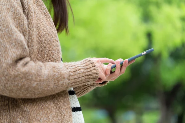 Mulher usando telefone celular no parque ao ar livre — Fotografia de Stock