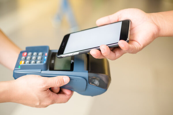 Woman using cellphone for paying the bill