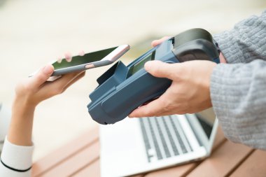Fatura ödeme için cep telefonu kullanan kadın