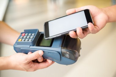 Fatura ödeme için cep telefonu kullanan kadın
