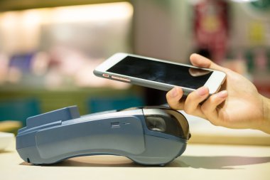 Fatura ödeme için cep telefonu kullanan kadın