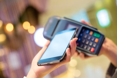 Fatura ödeme için cep telefonu kullanan kadın