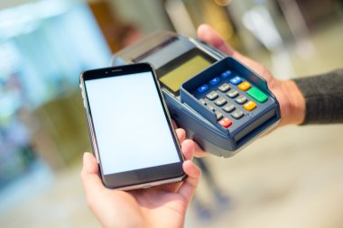 Fatura ödeme için cep telefonu kullanan kadın