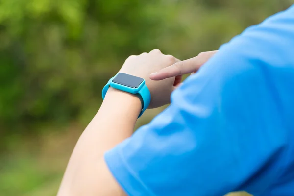 Człowiek za pomocą zegarka smartwatch z Odzież sportowa — Zdjęcie stockowe