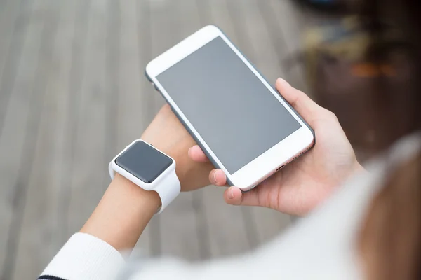 Frau verbindet Smartwatch und Handy — Stockfoto