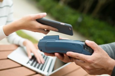 Fatura ödeme için cep telefonu kullanan kadın