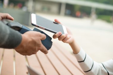 Fatura ödeme için cep telefonu kullanan kadın