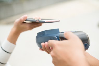 Fatura ödeme için cep telefonu kullanan kadın
