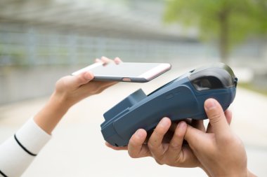 Fatura ödeme için cep telefonu kullanan kadın