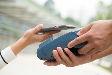 Fatura ödeme için cep telefonu kullanan kadın