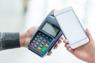 Fatura ödeme için cep telefonu kullanan kadın