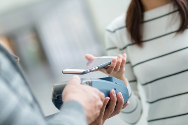 Fatura ödeme için cep telefonu kullanan kadın