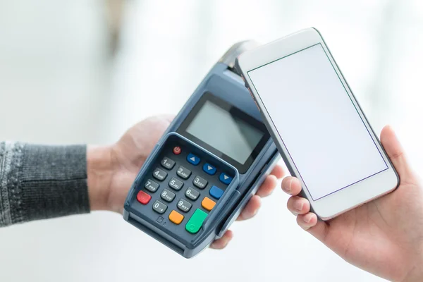 Woman using cellphone for paying the bill