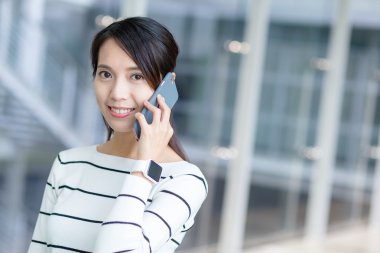 Kadın cep telefonuyla konuşuyor.