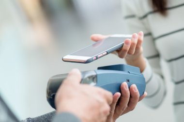Fatura ödeme için cep telefonu kullanan kadın