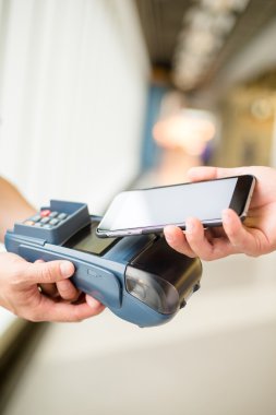 Fatura ödeme için cep telefonu kullanan kadın