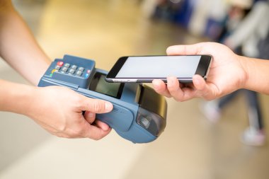 Fatura ödeme için cep telefonu kullanan kadın