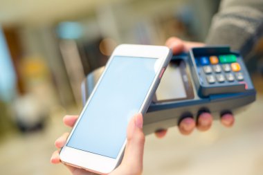 Fatura ödeme için cep telefonu kullanan kadın