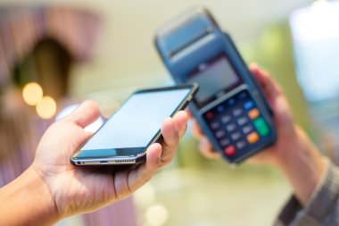 Fatura ödeme için cep telefonu kullanan kadın