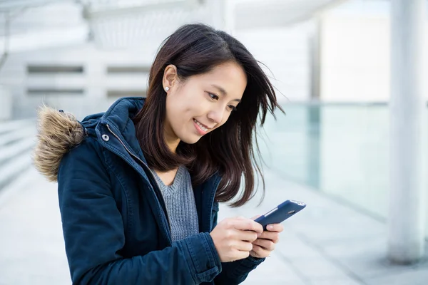 Vrouw op zoek naar mobiele telefoon — Stockfoto