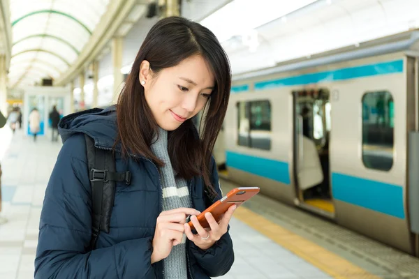 Mulher usando celular na plataforma do trem — Fotografia de Stock