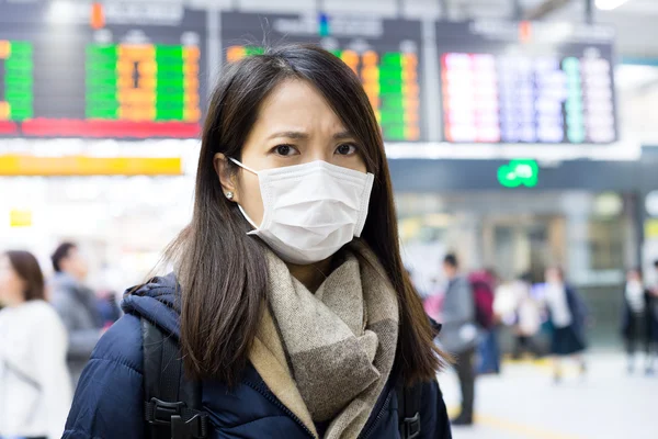Vrouw gezichtsmasker dragen in treinstation — Stockfoto