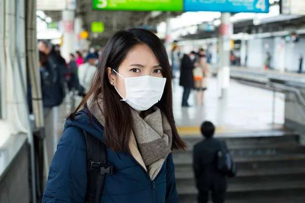 Vrouw gezichtsmasker dragen in treinstation — Stockfoto