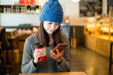 Kahve Dükkanı içinde cep telefonu kullanan kadın