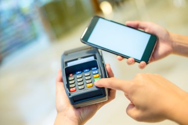 Fatura ödeme için cep telefonu kullanan kadın