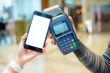 Fatura ödeme için cep telefonu kullanan kadın
