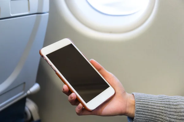 Woman using cellphone inside air plane — Stock Photo, Image