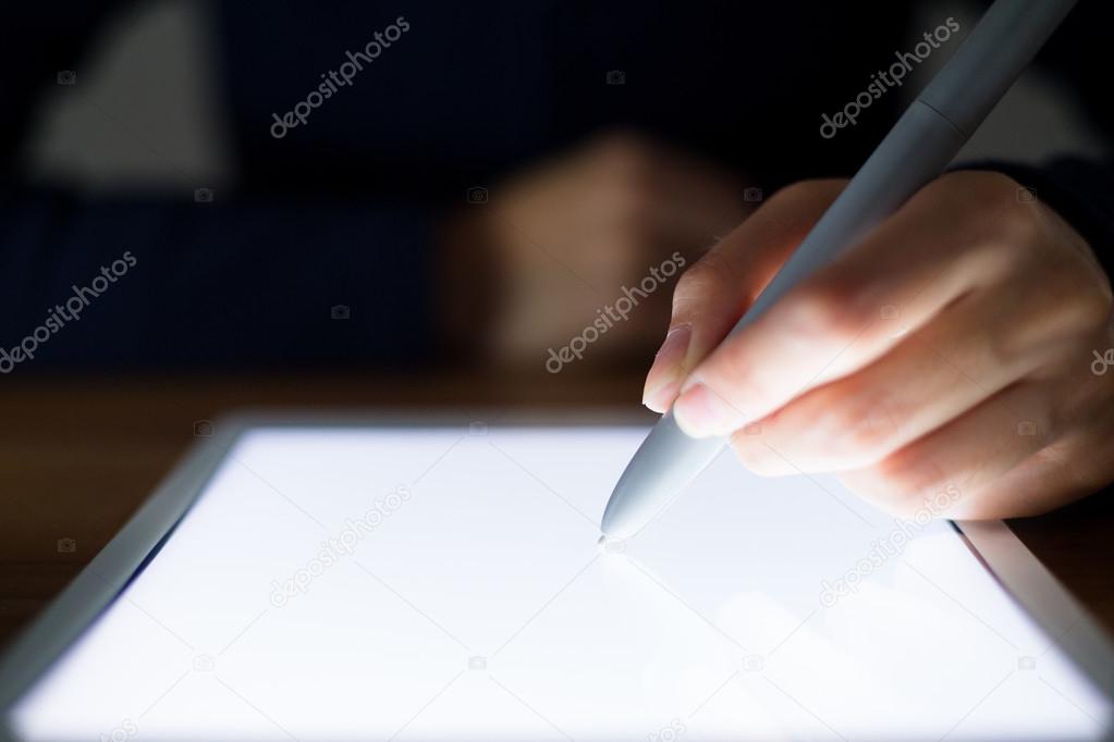 Woman writing something on digital tablet