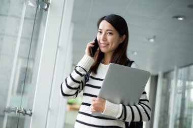 Cep telefonuyla konuşan genç bir kadın.