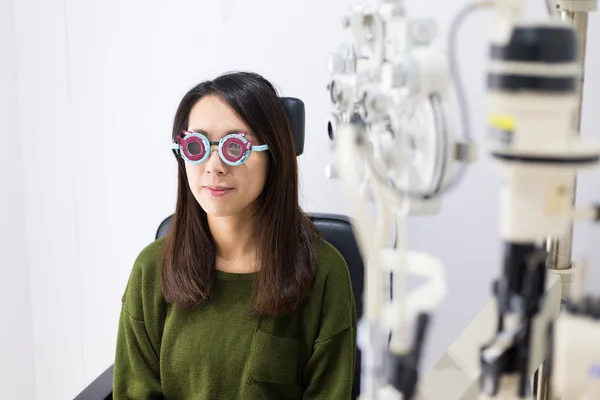 Mulher fazendo teste de olho na clínica óptica — Fotografia de Stock