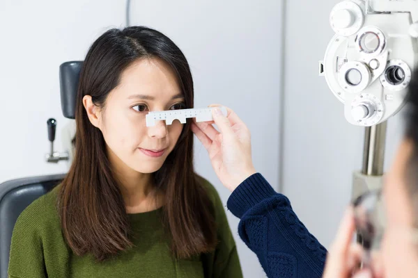 Kvinne som tar øyeprøve på optisk klinikk – stockfoto