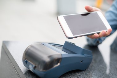 Fatura ödeme için cep telefonu kullanan kadın