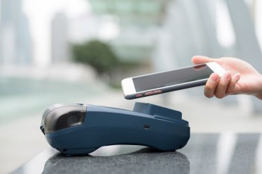 Fatura ödeme için cep telefonu kullanan kadın