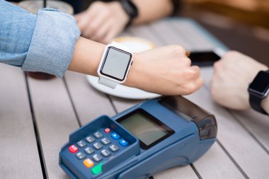 Kadınlar akıllı saatle NFC teknolojisiyle ödeme yapıyorlar.