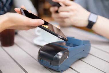 Fatura ödeme için cep telefonu kullanan kadın