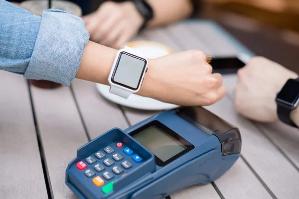 Mujer paga por reloj inteligente con tecnología NFC — Foto de Stock