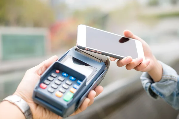 Vrouw met behulp van de mobiele telefoon voor het betalen van de rekening — Stockfoto